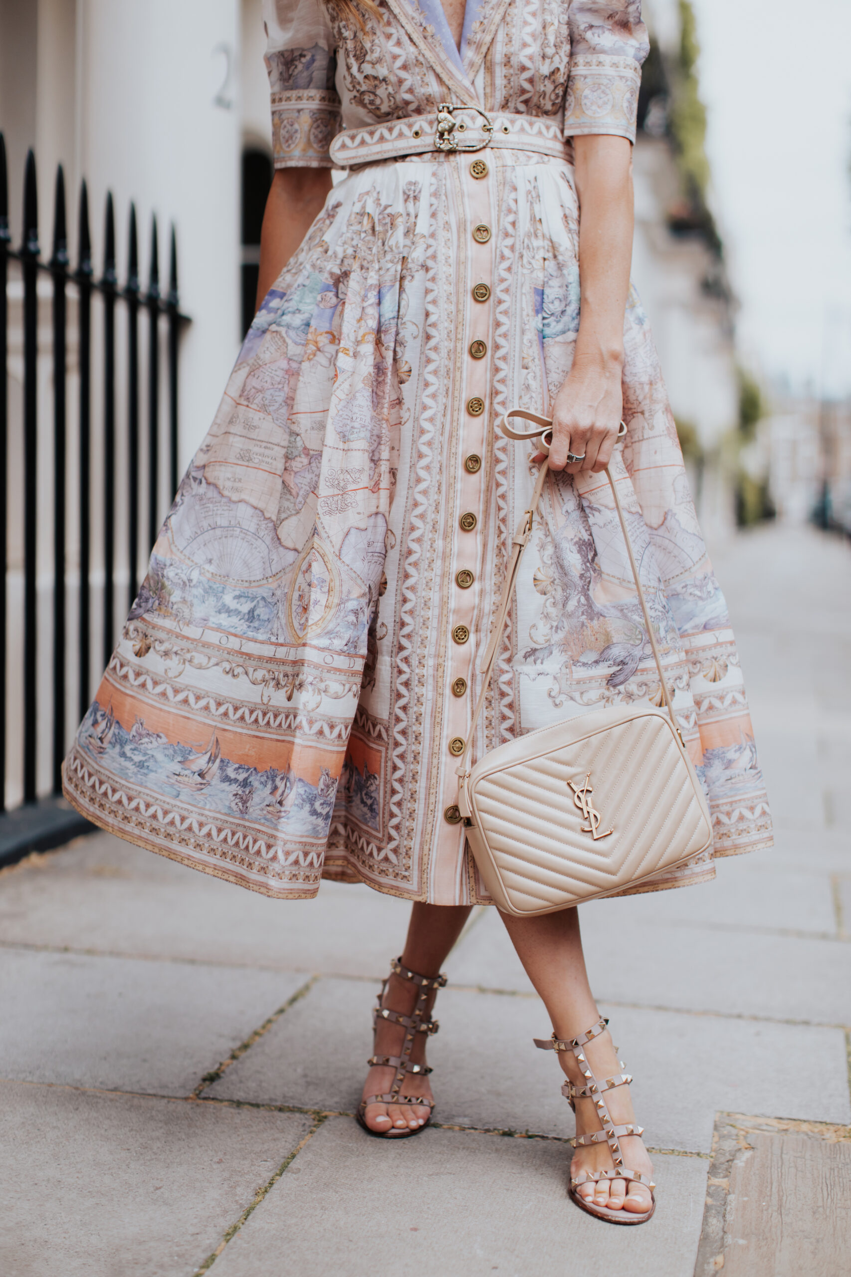 https://alysonhaley.com/wp-content/uploads/2023/06/brunette-woman-wearing-zimmerman-high-tide-map-print-shirt-dress-valentino-rockstud-heeled-sandals-in-london17-scaled.jpg